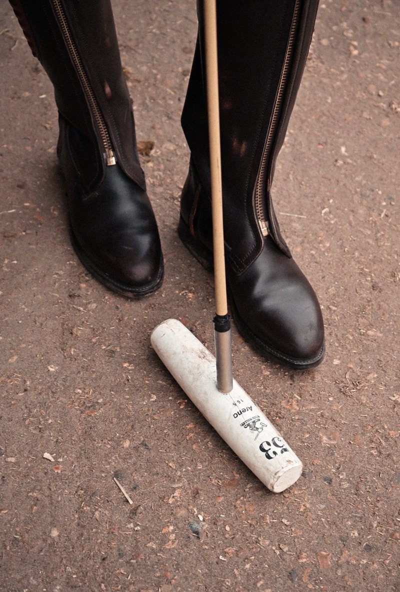 Polo boots beside a mallet head