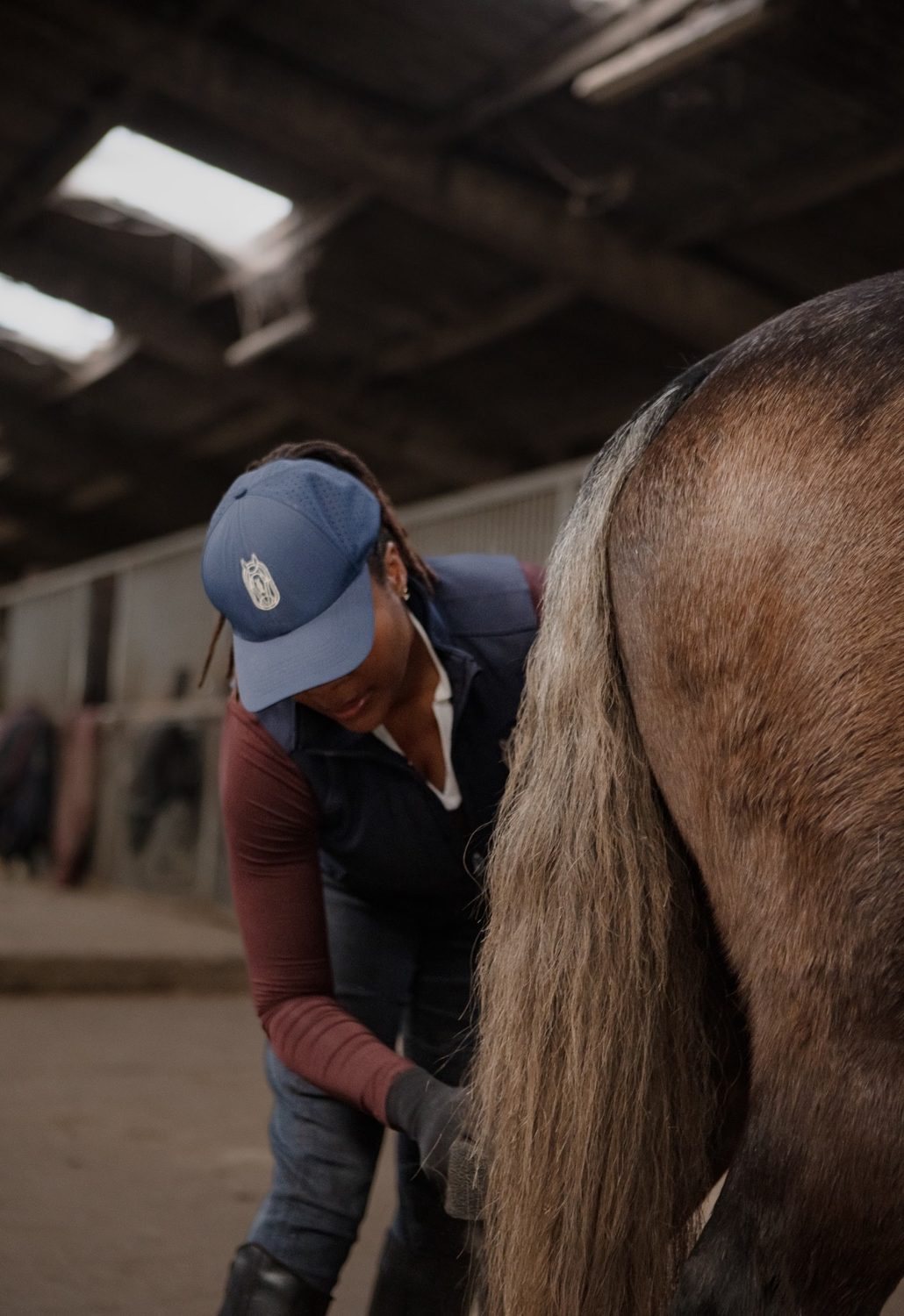 Champion Pride handler grooming a horse in a barn