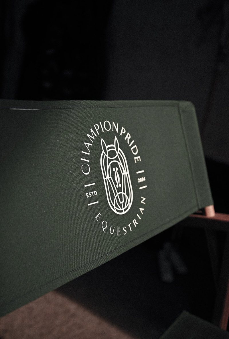 Champion Pride crest on a green director's chair in low light